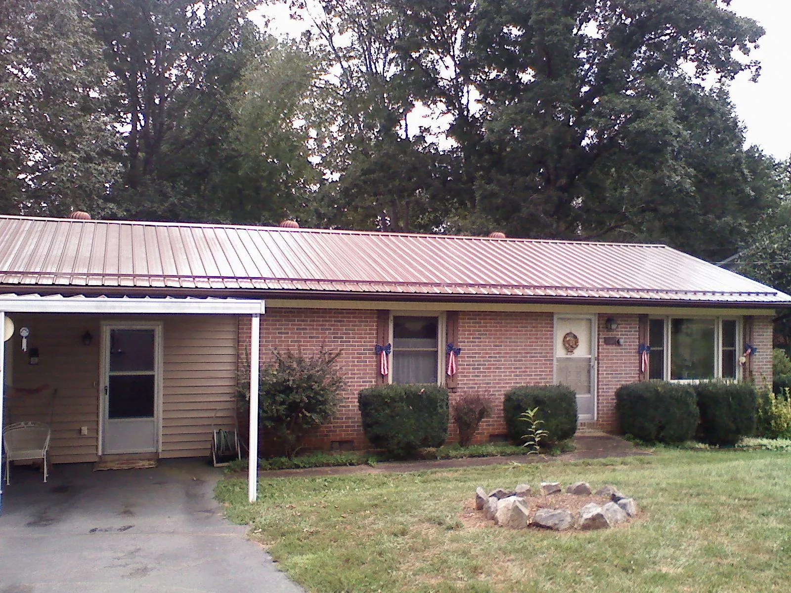 Bronze metal roof and carport on a brick ranch home — Roof Repair work by our crew in Holmen